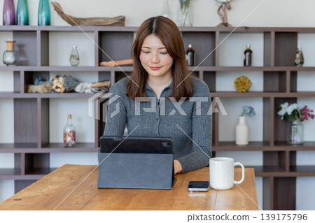 Portrait of a woman working with a tablet (working from home/desk work) 139175796