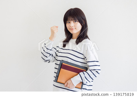 一位年輕女子擺出勝利的姿勢——這是成功和激勵的象徵。 一位年輕女子擺出勝利的姿勢——這是成功和激勵的象徵。 139175819