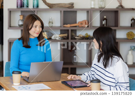 一位年輕的女商人正在咖啡廳式的辦公室開會。 139175820