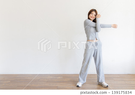 Young woman stretching; healthy lifestyle with body care at home Young woman stretching; healthy lifestyle with body care at home 139175834