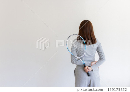 一位年輕女子背著網球拍——從背後展現了她熱愛運動的生活方式。 139175852