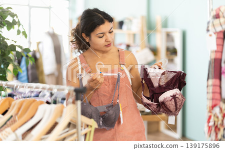 Attentive young girl choosing bra in clothing store 139175896