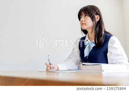 Portrait of a female student studying (notebook and textbook) Portrait of a female student studying (notebook and textbook) 139175904