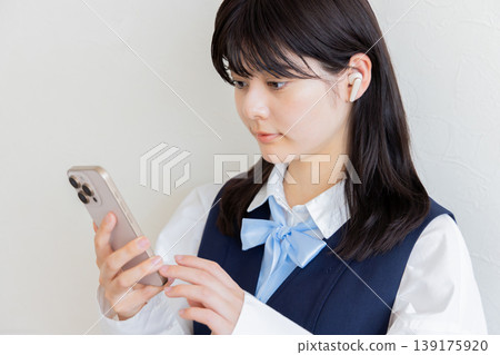 一位戴著耳機使用智慧型手機的高中女生-數位生活與學習圖片 一位戴著耳機使用智慧型手機的高中女生-數位生活與學習圖片 139175920