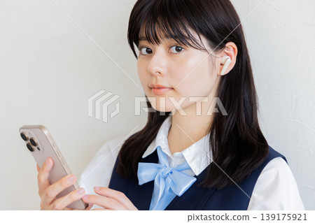 一位戴著耳機使用智慧型手機的高中女生－數位生活與學習圖片 139175921