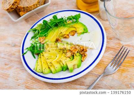 Avocado and cheese served with arugula and walnuts Avocado and cheese served with arugula and walnuts 139176150