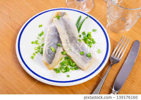 Herring slices served with onions on platter Herring slices served with onions on platter 139176160