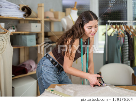 Woman tailor cutting fabric on table Woman tailor cutting fabric on table 139176164