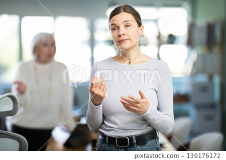 Sad woman staff stands in office Sad woman staff stands in office 139176172