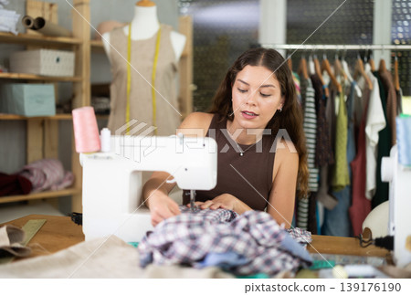 Female fashion designer sewing to order in the workshop Female fashion designer sewing to order in the workshop 139176190