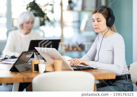 Two businesswomen work on laptops in modern company office Two businesswomen work on laptops in modern company office 139176325