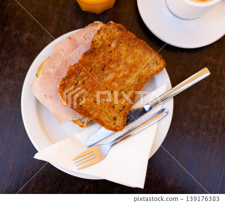 There is thin slice of soft and juicy ham between two slices of bread. There is thin slice of soft and juicy ham between two slices of bread. 139176383