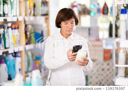 Elderly woman scanning qr code for liquid soap Elderly woman scanning qr code for liquid soap 139176397