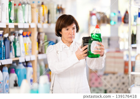 Elderly woman scanning qr code for dishwashing Elderly woman scanning qr code for dishwashing 139176418