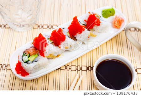 Sushi roll uramaki - tobiko roll with salmon, avocado, pepino, tobiko Sushi roll uramaki - tobiko roll with salmon, avocado, pepino, tobiko 139176435