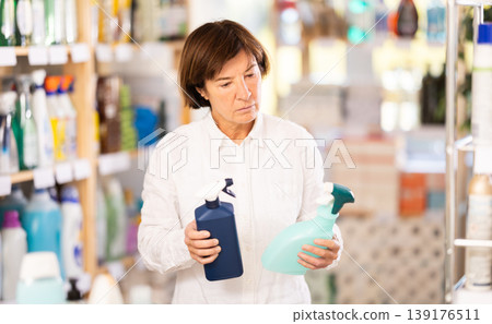 Elderly woman chooses cleaning spray in store 139176511
