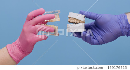 Modern vs traditional dentistry concept. Comparing transparent anatomical 3D jaw model with gypsum plaster cast impression on blue background. Modern vs traditional dentistry concept. Comparing transparent anatomical 3D jaw model with gypsum plaster cast impression on blue background. 139176513