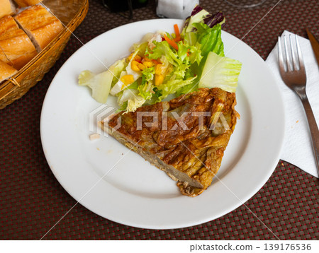 Traditional Spanish artichoke tortilla with fresh salad 139176536