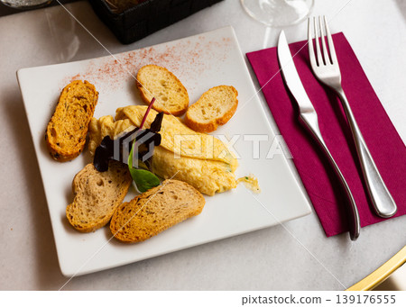Tasty and nutritious omelette served with crispy toast decorated with herbs Tasty and nutritious omelette served with crispy toast decorated with herbs 139176555