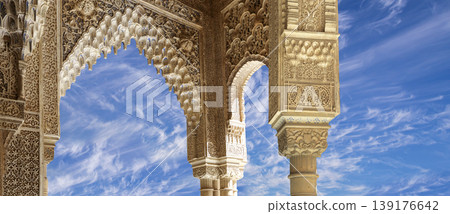 Arches in Islamic (Moorish) style (against the background of a beautiful sky with clouds) in Alhambra, Granada, Spain 139176642