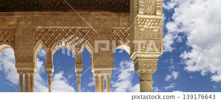 Arches in Islamic (Moorish) style (against the background of a beautiful sky with clouds) in Alhambra, Granada, Spain Arches in Islamic (Moorish) style (against the background of a beautiful sky with clouds) in Alhambra, Granada, Spain 139176643