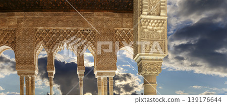 Arches in Islamic (Moorish) style (against the background of a beautiful sky with clouds) in Alhambra, Granada, Spain Arches in Islamic (Moorish) style (against the background of a beautiful sky with clouds) in Alhambra, Granada, Spain 139176644