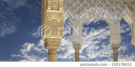 Arches in Islamic (Moorish) style (against the background of a beautiful sky with clouds) in Alhambra, Granada, Spain Arches in Islamic (Moorish) style (against the background of a beautiful sky with clouds) in Alhambra, Granada, Spain 139176652