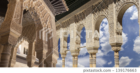 Arches in Islamic (Moorish) style (against the background of a beautiful sky with clouds) in Alhambra, Granada, Spain Arches in Islamic (Moorish) style (against the background of a beautiful sky with clouds) in Alhambra, Granada, Spain 139176663