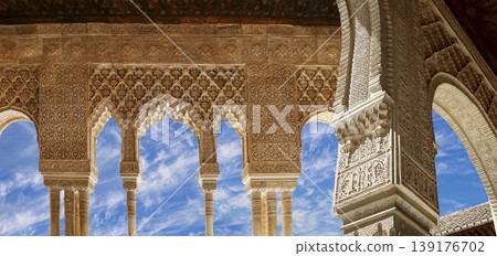 Arches in Islamic (Moorish) style (against the background of a beautiful sky with clouds) in Alhambra, Granada, Spain 139176702