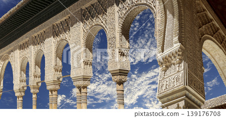 Arches in Islamic (Moorish) style (against the background of a beautiful sky with clouds) in Alhambra, Granada, Spain 139176708