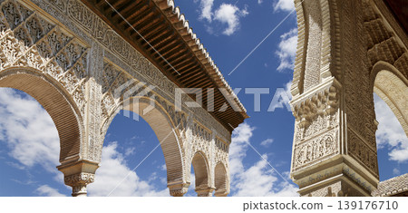 Arches in Islamic (Moorish) style (against the background of a beautiful sky with clouds) in Alhambra, Granada, Spain 139176710