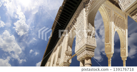 Arches in Islamic (Moorish) style (against the background of a beautiful sky with clouds) in Alhambra, Granada, Spain Arches in Islamic (Moorish) style (against the background of a beautiful sky with clouds) in Alhambra, Granada, Spain 139176718