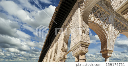 Arches in Islamic (Moorish) style (against the background of a beautiful sky with clouds) in Alhambra, Granada, Spain 139176731
