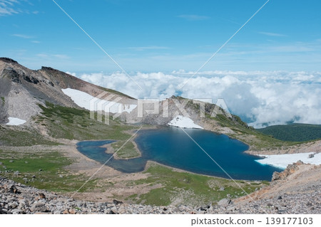 Gongen Pond on Mount Norikura: A crater lake in the sky, surrounded by snowfields and rugged rock faces. Gongen Pond on Mount Norikura: A crater lake in the sky, surrounded by snowfields and rugged rock faces. 139177103