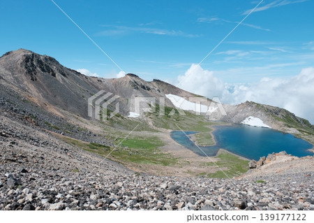 Gongen Pond on Mount Norikura: A crater lake in the sky in early summer, surrounded by vast scree fields and ridgelines. 139177122