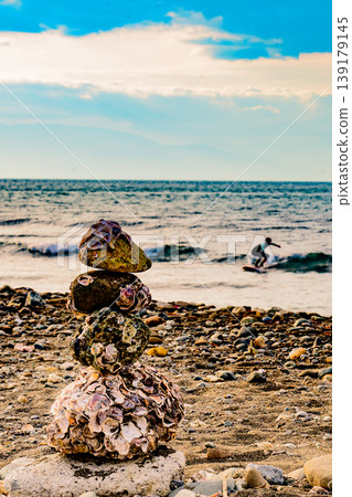 海灘上的石牆守護著衝浪者;一片寧靜祥和。 海灘上的石牆守護著衝浪者;一片寧靜祥和。 139179145