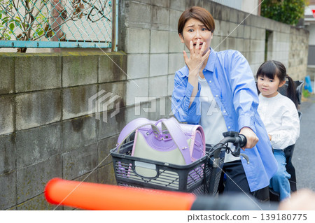 一名女子騎著腳踏車,後座載著一名小學生。 一名女子騎著腳踏車,後座載著一名小學生。 139180775