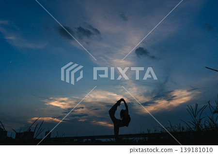 A woman expressing herself against the backdrop of a sunset. 139181010