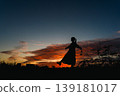 一個女人抬頭望著夕陽的天空 139181017