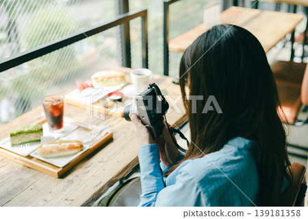 一位女士正在為一家咖啡館拍照。 一位女士正在為一家咖啡館拍照。 139181358