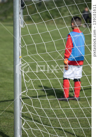 Close-up of soccer goals on an outdoor soccer field, the team of soccer players is blurred. Close-up of soccer goals on an outdoor soccer field, the team of soccer players is blurred. 139181611