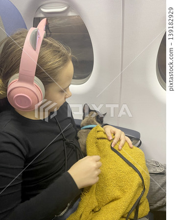 Portrait of Child sitting in cabin airplane with Cat. Travel with pet Portrait of Child sitting in cabin airplane with Cat. Travel with pet 139182929