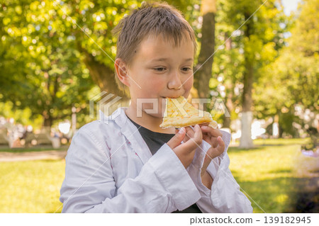 Happy child boy eating in park Happy child boy eating in park 139182945