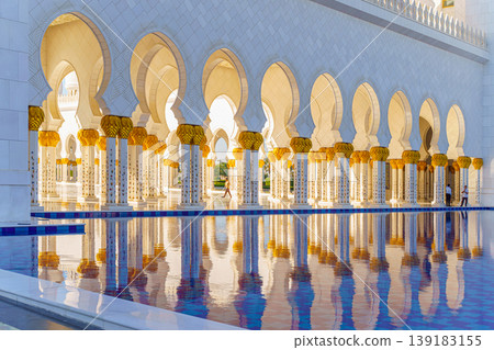 Abu Dhabi, United Arab Emirates - Jan 10 2024, panoramic view of Sheikh Zayed Grand Mosque colonnade with arches and pool on foreground, at daytime, Abu Dhabi, United Arab Emirates Abu Dhabi, United Arab Emirates - Jan 10 2024, panoramic view of Sheikh Zayed Grand Mosque colonnade with arches and pool on foreground, at daytime, Abu Dhabi, United Arab Emirates 139183155