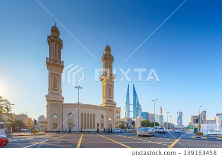 Manama, Bahrain - Jan 08 2024, Close up view of Ras Rumman Mosque, with the World trade center if Bahrain behind it, at daytime, Manama, Bahrain Manama, Bahrain - Jan 08 2024, Close up view of Ras Rumman Mosque, with the World trade center if Bahrain behind it, at daytime, Manama, Bahrain 139183458