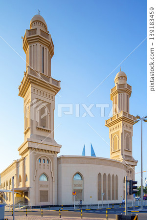 Manama, Bahrain - Jan 08 2024, Close up view of Ras Rumman Mosque, with the World trade center if Bahrain behind it, at daytime, Manama, Bahrain Manama, Bahrain - Jan 08 2024, Close up view of Ras Rumman Mosque, with the World trade center if Bahrain behind it, at daytime, Manama, Bahrain 139183459