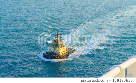 Manama, Bahrain - Jan 08 2024, Aerial view of tugboat, boat, what passing by, with blue sea, at daytime, Manama, Bahrain Manama, Bahrain - Jan 08 2024, Aerial view of tugboat, boat, what passing by, with blue sea, at daytime, Manama, Bahrain 139183633
