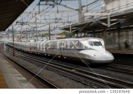 A powerful scene of a passing Shinkansen train captured with zoom and panning. A powerful scene of a passing Shinkansen train captured with zoom and panning. 139183648