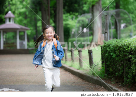A full-body portrait of an energetic elementary school student running with a schoolbag, representing the school commute and growth of a young elementary school student going to and from school. A full-body portrait of an energetic elementary school student running with a schoolbag, representing the school commute and growth of a young elementary school student going to and from school. 139183927