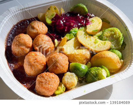 Close-up Swedish meatball meal with potato and Brussels sprout served in a takeaway container. Comfort food, fast lunch, convenience, and casual dining experience Close-up Swedish meatball meal with potato and Brussels sprout served in a takeaway container. Comfort food, fast lunch, convenience, and casual dining experience 139184089